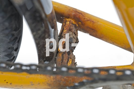 Eine rostige Verstrebung eines Fahrradrahmens mit abgeblättertem Lack.