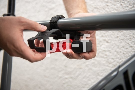 Die Halterung für das kleine Schloss wird einfach per Klettverschluss am Rahmen befestigt. So kann sie schnell entfernt werden, wenn eine Tour ohne Stopp geplant ist. Die Halterung ist nicht im Lieferumfang enthalten und kann optional dazugekauft werden.