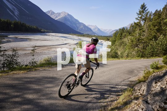 Frau auf Gravelbike in den Bergen.