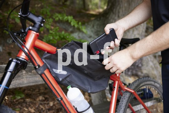 Mann verstaut Handy in Rahmentasche.