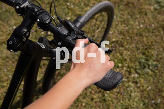 Hand greift mit Daumen oben an Lenker.