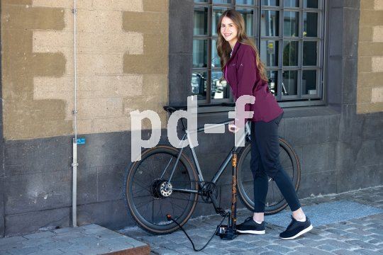Frau pumpt Fahrradreifen auf