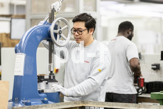 Mann steht an Maschine