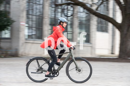 Frau fährt mit E-Bike durch Stadt