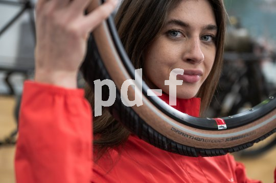 Der "Marathon Efficiency" verbindet hohen Pannenschutz mit geringem Rollwiderstand. Frau schaut durch Fahrradreifen