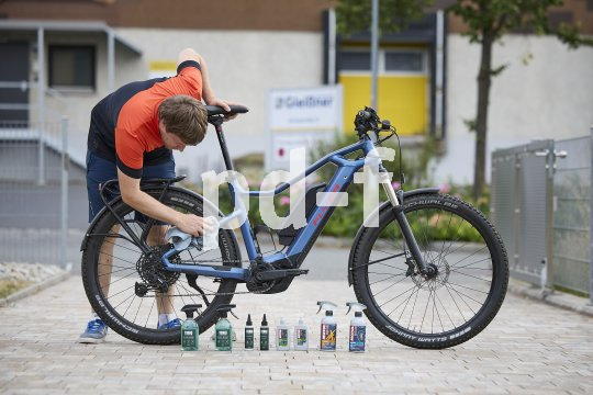 Mann putzt E-Bike.
