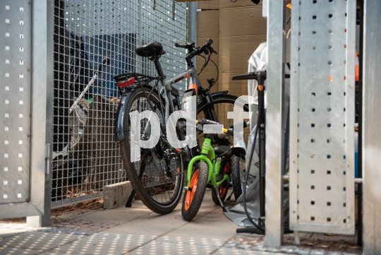 Fahrräder in einem Metallverschlag mit Tür.