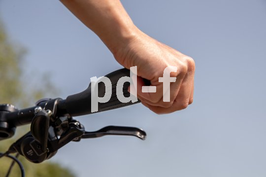 Hand greift per Außengriff an Lenker.