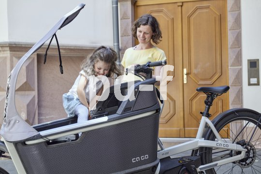 Einfaches, eigenständiges Zusteigen für Kinder ist ein wesentliches Kriterium für Lastenräder. Kind und Frau mit Lastenrad