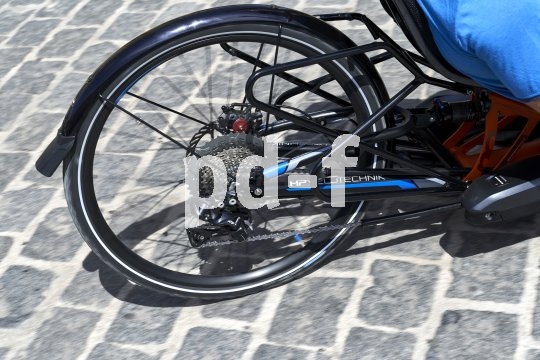 Die Bildunterschrift wird in Bälde eingefügt. Sie können uns aber gern auch per E-Mail oder Telefon kontaktieren, wir helfen gerne weiter. Das Hinterrad eines Liegerades auf Kopfsteinpflaster.