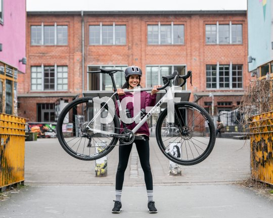 Frau hebt Gravelbike hoch