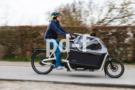 Lastenräder bieten Familien im Alltag viele Möglichkeiten. Mann fährt mit Lastenrad