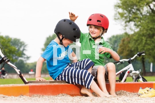 Ein gutes Zeichen dafür, dass der Kopfschutz nicht als Fremdkörper empfunden wird: Beim spiel lassen die Jungs ihn einfach auf dem Kopf. Doch wenn es aufs Klettergerüst geht, müssen Mama und Papa intervenieren.