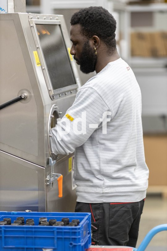 Mann steht an Maschine