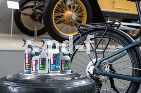 Mehrere Plastikflaschen mit Pflegemitteln vor einem Fahrrad.