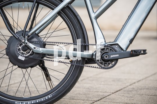 Detailansicht eines E-Bikes mit Hinterradmotor und Riemenantrieb.