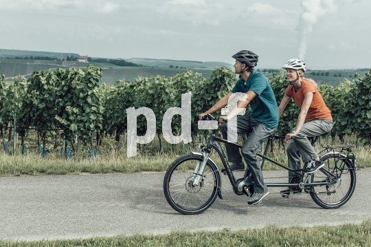 Radelndes Paar mit der Kraft von drei: Tandems bieten ohnehin flotten Fahradspaß, doch mit Zusatzantrieb wird das zweisame Radeln noch einmal schneller und komfortabler.