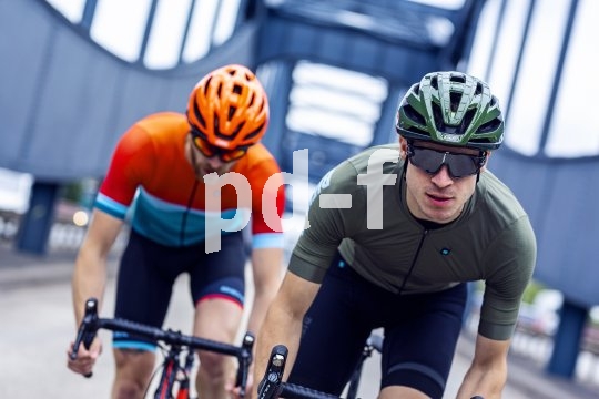 Zwei Rennradfahrer fahren auf den Betrachter zu.