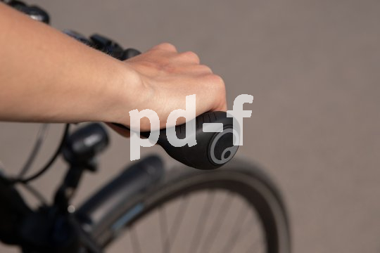 Hand greift per Standardgriff an Lenker.