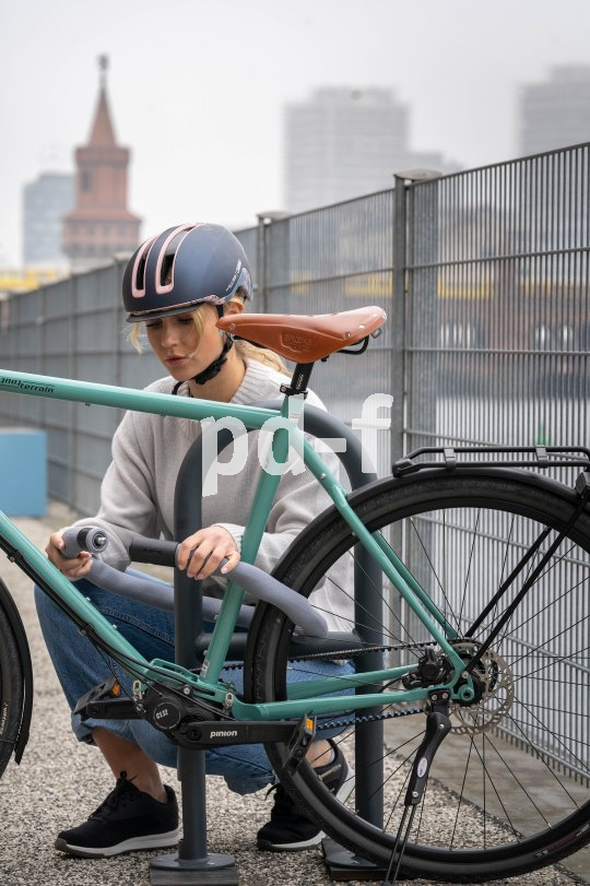 Frau schließt Fahrrad an 