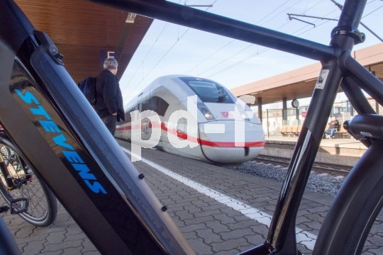 Im ICE 4 gibt es ein spezielles Fahrradabteil zur Mitnahme von Fahrrädern oder E-Bikes. Ein Fernverkehrszug der Deutschen Bahn durch einen E-Bike-Rahmen fotografiert.