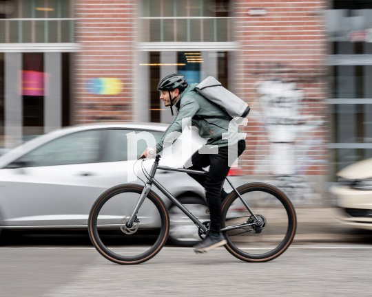 In der Stadt ist das Fahrrad ein praktisches Verkehrsmittel. Ein Mann fährt auf einem Fahrrad durch die Stadt