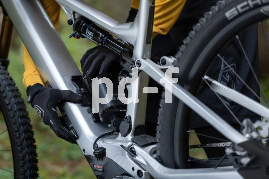 Die Bildunterschrift wird in Bälde eingefügt. Sie können uns aber gern auch per E-Mail oder Telefon kontaktieren, wir helfen gerne weiter. Eine Person hantiert am Akku im Rahmen eines E-Mountainbikes.