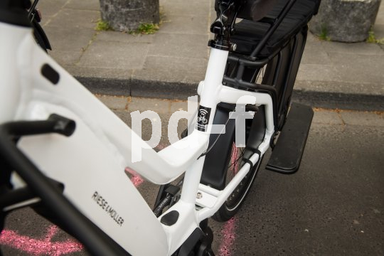 Detailaufnahme eines E-Bike-Rahmens mit einem Aufkleber, der auf einen GPS-Tracker hinweist.