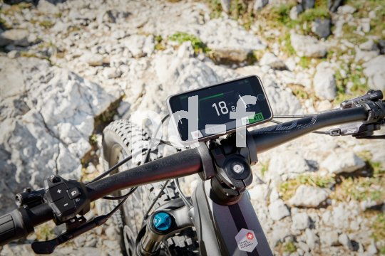 Ein Smartphone am Lenker eines E-Bikes.
