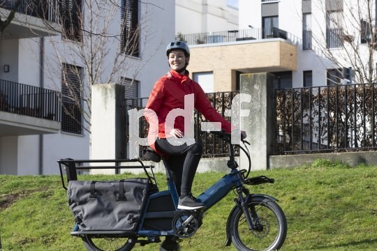 Frau steht mit Cargobike