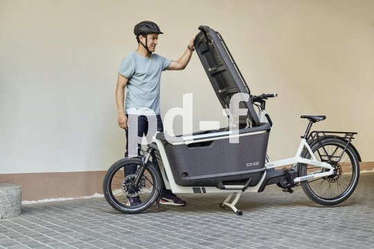 Mann öffnet Box an Lastenrad