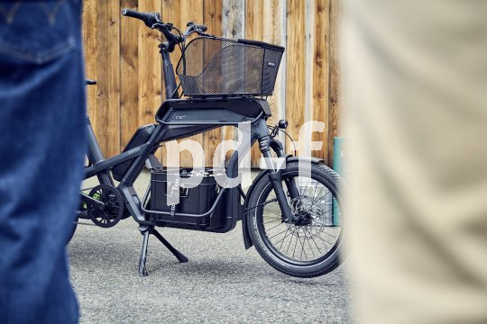 Cargobike steht vor Holzwand.