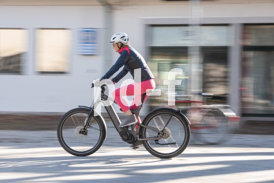 Eine Person fährt auf einem E-Bike durch die Innenstadt.