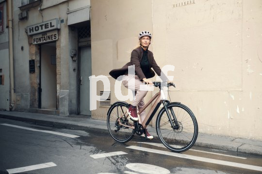 Eine Frau fährt auf einem Fahrrad durch eine Stadt.