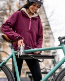 Eine Frau schließt ein Fahrrad mit einem Schloss an einem Fahrradparker an