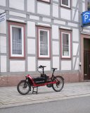 Ein Lastenrad vor einem Fachwerkhaus.