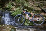 Mountainbike steht vor Wasserfall.