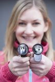 Eine Frau hält zwei Fahrradscheinwerfer vor sich.