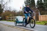 Mann fährt mit E-Bike und Anhänger