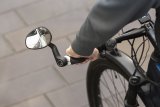 Ein Rückspiegel am Lenker eines Fahrrads.