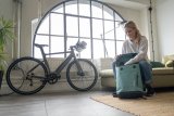 Frau packt Fahrradrucksack in Wohnung