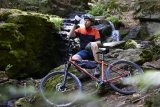 Mountainbiker sitzt vor Wasserfall