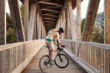 Mann mit Gravelbike auf Brücke