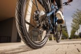 Detailansicht des Hinterreifens eines Fahrrades beim Rollen über eine gepflasterte Oberfläche.