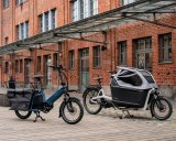 Zwei Lastenräder vor einem Gebäude mit Ziegelfassade.