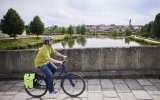Mann fährt mit Fahrrad über historische Brücke.
