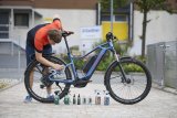 Mann putzt E-Bike.