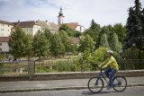 Mann fährt mit Fahrrad vor Kirche