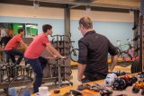 Eine Person sitzt in einem Fahrradladen auf einem Ergometer. Eine zweite Person schaut von der Seite darauf.