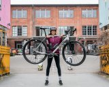 Frau hebt Gravelbike hoch